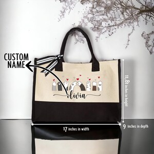 May include: A beige and brown canvas tote bag with black handles. The bag features a design of cats with hearts and the name "olivia" printed on the front. The bag measures 17 inches wide, 11.81 inches high, and 9 inches deep.