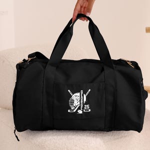 May include: Black duffel bag with a white hockey player graphic and the text "GEORGE 25" on the front pocket.