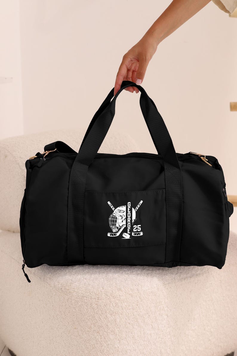 May include: Black duffel bag with a white hockey player graphic and the text "GEORGE 25" on the front pocket.