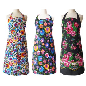 May include: Three floral print aprons with adjustable straps. The aprons are black with pink and white flowers, white with multi-colored flowers, and black with blue and yellow flowers.