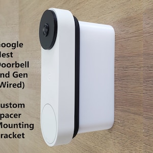 May include: White Google Nest Doorbell 2nd Gen (Wired) mounted on a wood surface with a black custom spacer mounting bracket.