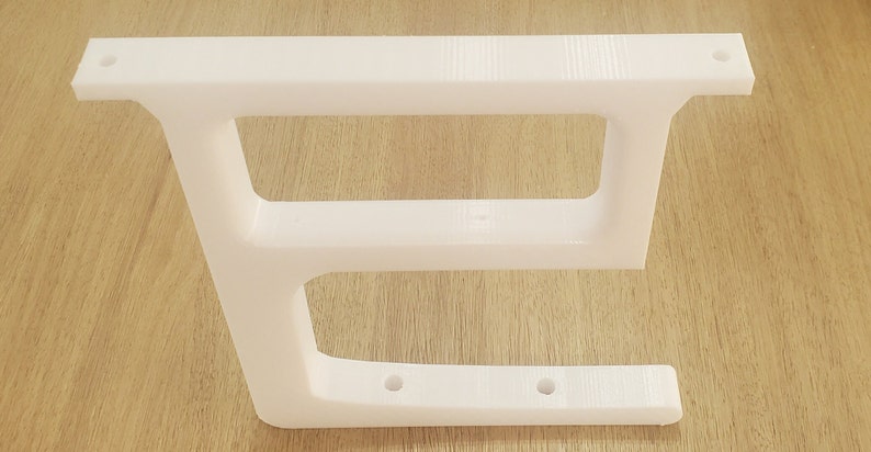 May include: White plastic shelf bracket with two shelves and five holes for mounting.