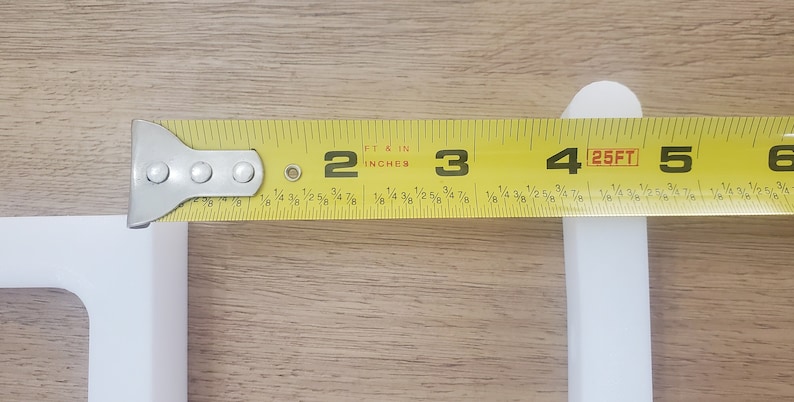 May include: A yellow measuring tape with black markings is extended to show a measurement of 4 feet. The tape reads "25FT" at the 4-foot mark.