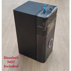 May include: A black doorbell camera mount with a silver button. The doorbell is not included.