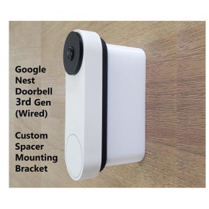 May include: White Google Nest Doorbell 3rd Gen (Wired) with a custom spacer mounting bracket. The doorbell has a black camera lens and a white circular button. The text "Google Nest Doorbell 3rd Gen (Wired) Custom Spacer Mounting Bracket" is visible.