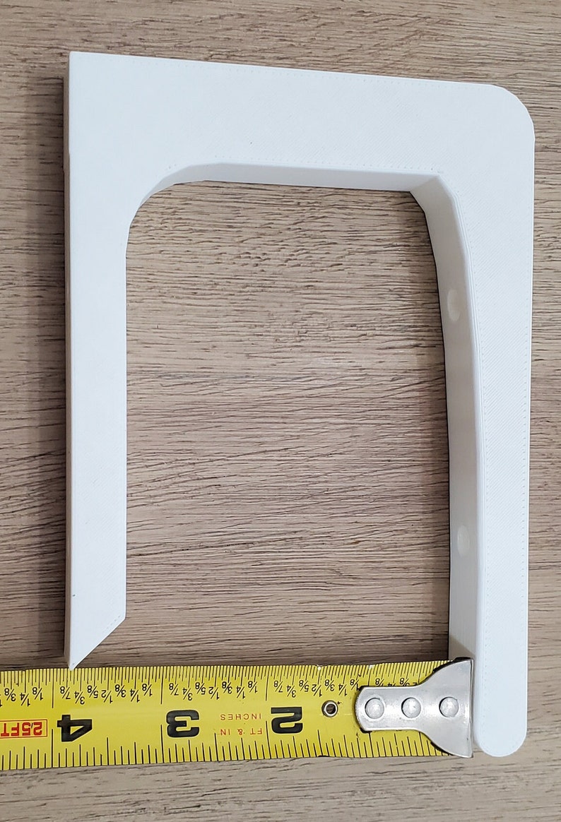Op de afbeelding: Een witte kunststof hoekbeugel met vier gaten. De beugel is 7,6 cm breed en 5,1 cm hoog.
