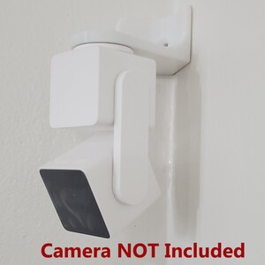 May include: White wall mount for a security camera. The mount is made of plastic and has a swivel design. Camera NOT Included.