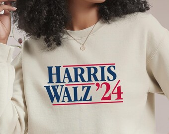 May include: A cream-colored sweatshirt with the text "HARRIS WALZ '24" in blue and red lettering.