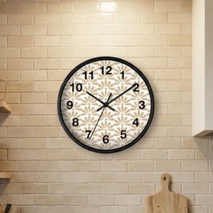 May include: A round wall clock with a black frame and a beige and white fan-shaped pattern on the face. The clock features black Arabic numerals from 1 to 12 and thin black hour, minute, and second hands centered on the dial.