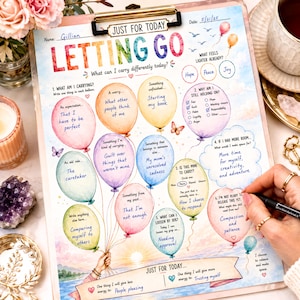 May include: A clipboard featuring a printed worksheet titled Letting Go with colorful watercolor balloons, each containing handwritten prompts and reflections. The page includes sections for daily intentions, emotional check-ins, and space for personal notes, all set against a soft sunrise landscape illustration.