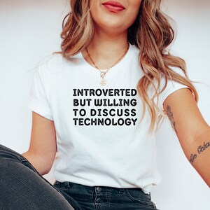 May include: A white t-shirt with black text that reads "Introverted but willing to discuss technology".