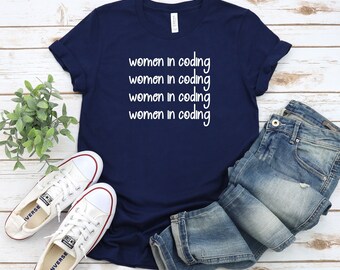 May include: A navy blue t-shirt with the text "women in coding" repeated four times in white.