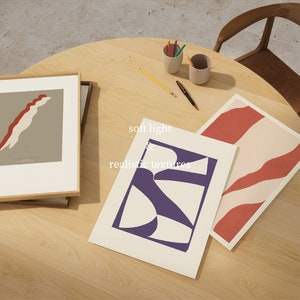 May include: Three framed abstract art prints with geometric shapes in red, white, and purple on a light wood surface. The text "soft light & realistic textures" is written on the surface.
