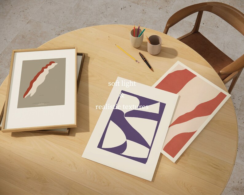 May include: Three framed abstract art prints with geometric shapes in red, white, and purple on a light wood surface. The text "soft light & realistic textures" is written on the surface.