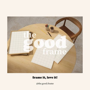 May include: A wooden table with two white gridded papers and a wooden frame with a white gridded paper inside. The text "the good frame" is in white letters on the table.