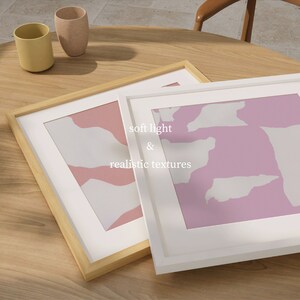 May include: Two framed abstract art prints with pink and white geometric shapes. The top print has a white frame and the bottom print has a natural wood frame. The text "soft light & realistic textures" is printed on the white frame.