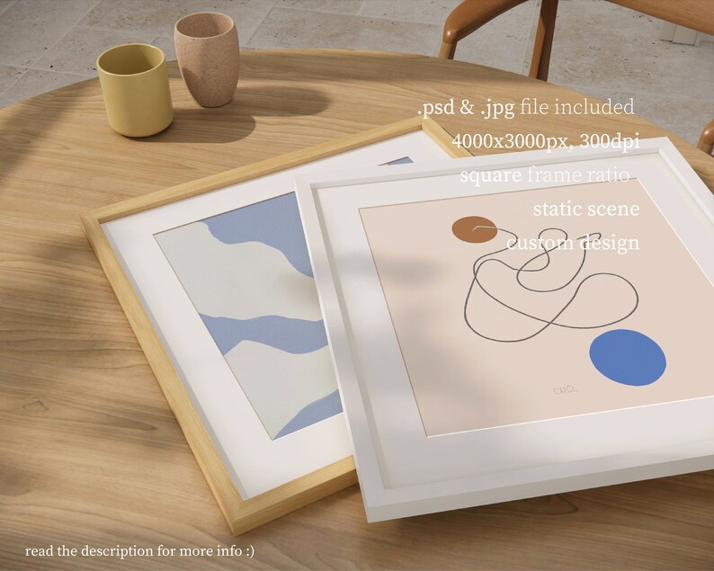 May include: Two framed abstract art prints on a wooden table. The print on the left has a blue and white abstract design. The print on the right has a brown and blue abstract design with a black line drawing. The text on the print reads "static scene custom design".