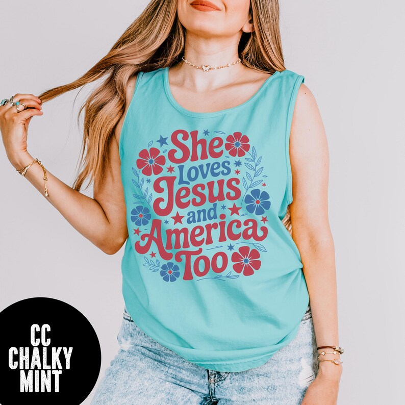 May include: A turquoise tank top with the text "She Loves Jesus and America Too" in red and blue. The design includes floral and star accents. The tank top is sleeveless and made of a soft material.