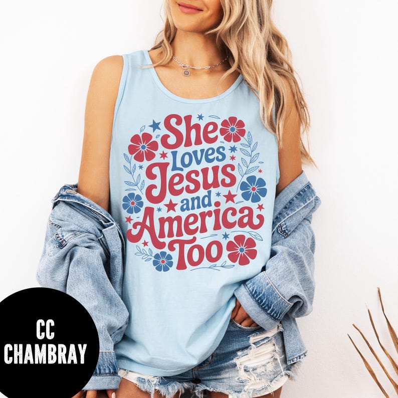 May include: Light blue tank top with the text "She Loves Jesus and America Too" in red and white. The design includes red and blue floral and star accents. The tank top is sleeveless.