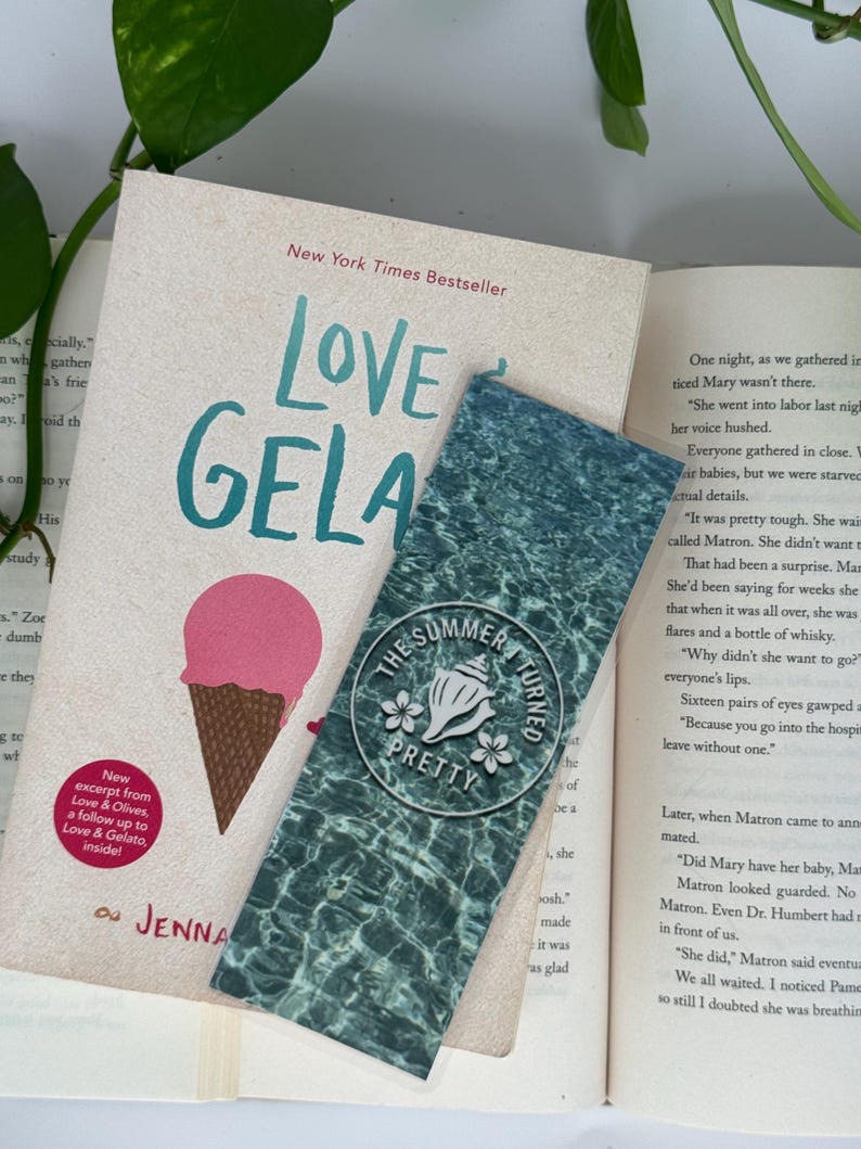 Peut inclure: Un livre intitul&eacute; "Love & Gelato" avec une illustration de cornet de glace rose et un marque-page. Le marque-page pr&eacute;sente un motif de surface d'eau et le texte "The Summer I Turned Pretty".