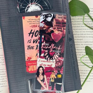 May include: A collection of bookmarks and a book. The bookmarks feature text and images, including a broken glass design, a quote, and a collage with the words "The Mindf*ck Series." The book is open, with text visible.
