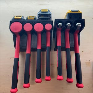 May include: A black wall-mounted storage rack with six slots for holding red-handled hammers and two slots for holding yellow and black battery packs.