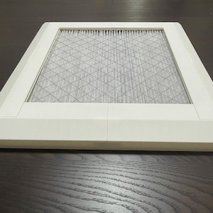 May include: A white rectangular air filter with a white mesh grid inside. The filter is designed to fit into a square opening.