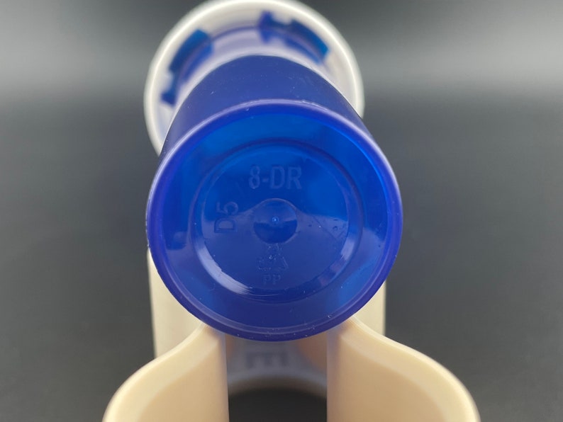 K&ouml;nnte beinhalten: Blaue Plastikflasche mit wei&szlig;em Deckel und dem Aufdruck "8-DR" auf dem Boden.