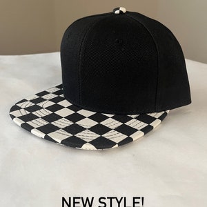 May include: Black and white chequered baseball cap with a black crown. The text "NEW STYLE! LIMITED QUANTITY" is printed below the cap.