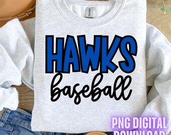 May include: A gray sweatshirt with the text "HAWKS baseball" in blue and black lettering. The text is in a bold, cartoon-like font. The sweatshirt is laying on a wooden surface with a pair of sandals and blue jeans.