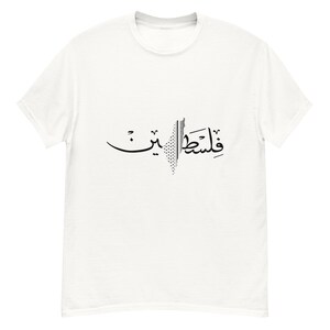 May include: White t-shirt with black Arabic calligraphy and a geometric design. The text appears to read "Palestine". The shirt is made of a soft material and has a classic crew neck.