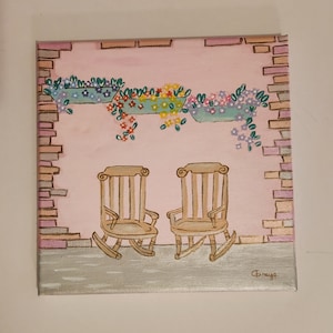 pink and gold vintage chairs painting and flowers in a wall.