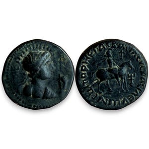 May include: Two antique bronze coins. One coin features a profile of a person, the other depicts a person on horseback. Both coins have visible inscriptions around the edges. The coins have a dark, aged appearance, suggesting historical significance.