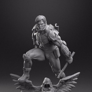 Può includere: Una statuetta grigia e dettagliata di un supereroe in piedi su una base rocciosa con una creatura simile a un uccello. Il supereroe indossa un costume con una cintura e un'arma.