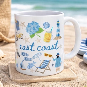 May include: White ceramic mug with a coastal theme. The mug features illustrations of a lighthouse, starfish, and the words "east coast" in blue script. Other images include a bicycle, sunglasses, and a beach chair.