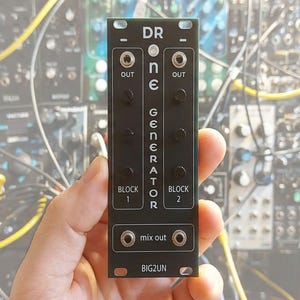 May include: A black Eurorack synthesizer module labeled DR ONE GENERATOR with white text. It features two sections labeled BLOCK 1 and BLOCK 2, each with an OUT jack and three control knobs. The bottom section has two mix out jacks and the text BIG2UN.
