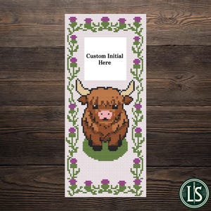 Könnte beinhalten: Kreuzstich-Lesezeichen mit einer braunen Highland-Kuh mit Hörnern, auf einer grünen Basis. Das Design umfasst einen weißen Rahmen mit dem Text "Custom Initial Here" und ist von einem Rand aus lila Disteln und grünen Blättern umgeben.