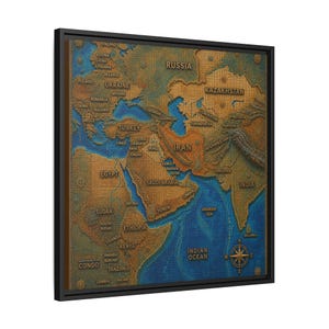 Könnte beinhalten: Ein gerahmtes Wandbild mit einer texturierten Reliefkarte des Nahen Ostens, Nordafrikas und Teilen Asiens. Die Landmassen sind in Bronze- und Goldtönen gehalten, während die Ozeane in tiefem Blau dargestellt sind. Enthält eine Windrose.