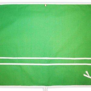 May include: Green canvas apron with two white pockets and white ties. The apron has a white border.