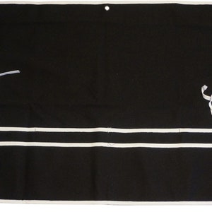 May include: Black canvas tool roll with white trim and two white straps. The roll has three pockets with white piping.