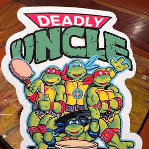 May include: Four Teenage Mutant Ninja Turtles, dressed in their signature bandanas, are playing a drum. The turtles are green with brown eyes and are wearing red, blue, orange, and purple bandanas. The drum is red and has a brown rim. The background is white with the words "DEADLY UNCLE" in green and red letters.