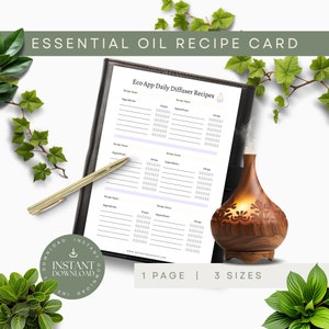 May include: An essential oil recipe card with the text "ESSENTIAL OIL RECIPE CARD" and "Eco App Daily Diffuser Recipes". A gold pen rests on the card, next to a wooden essential oil diffuser. The card is in a black binder. The text "INSTANT DOWNLOAD" is also visible.