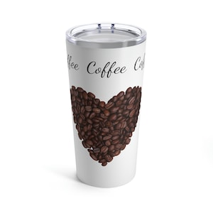 May include: White travel mug with a clear lid. The mug features a heart made of coffee beans and the word "Coffee" in a script font. A great gift for coffee lovers.