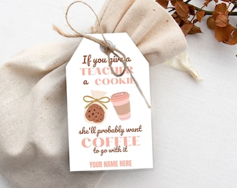 May include: A white gift tag with brown text that reads "If you give a teacher a cookie she'll probably want coffee to go with it."  The tag also features a brown cookie and a pink coffee cup.