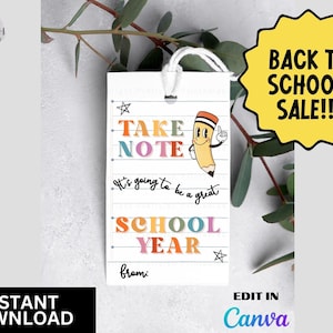 Pode incluir: Uma etiqueta branca com o texto "TAKE NOTE" e "SCHOOL YEAR" em letras coloridas, juntamente com um personagem de lápis de desenho animado. A etiqueta também inclui as frases "It's going to be a great" e "from:". Um gráfico de estrela amarela diz "BACK TO SCHOOL SALE!!!".