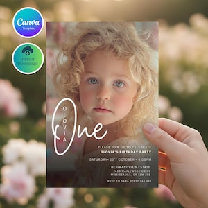 May include: A birthday party invitation featuring a young child with blonde hair and blue eyes. The invitation includes the name "Olovia" and the word "One" in a stylish font. Additional text provides party details, including the date, time, and location.