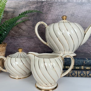 Sadler 5 pieces tea set, teapot creamer sugar bowl with lid. White with gold swirls. Made in England, number 1943