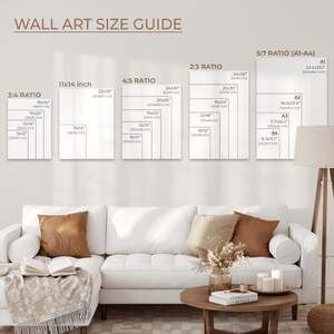 May include: A wall art size guide with different ratios and sizes listed in inches and centimeters. The guide shows the dimensions of various sizes of wall art, including 3:4, 4:5, 2:3, and 5:7 ratios. The guide is displayed on a white wall with a white couch and a wooden coffee table in front of it.