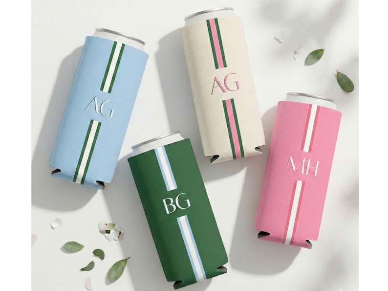 May include: Four personalised can coolers in light blue, cream, green, and pink. Each cooler features a vertical stripe design with initials and a white stripe. The initials are AG, BG, and MH.