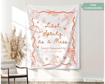 May include: White tapestry with orange illustrations and text. The design includes a sun, umbrella, citrus fruits, and a cocktail glass. Text reads "Last Spritz as a Miss" and "Emily's Bachelorette Destin, FL I Est. 2025".